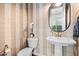 Stylish powder room with designer wallpaper, pedestal sink and oval mirror at 4615 E Navigator Ln, Phoenix, AZ 85050