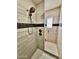 Modern shower boasts decorative stone tile, a sleek shower head, and a frameless glass door at 4615 E Navigator Ln, Phoenix, AZ 85050