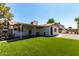 Large backyard with green artificial turf, covered patio, and well-maintained landscaping at 5302 W Poinsettia Dr, Glendale, AZ 85304