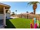 Spacious backyard with green artificial turf, block wall, and palm tree at 5302 W Poinsettia Dr, Glendale, AZ 85304