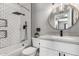 Modern bathroom with white subway tile, matte black fixtures, and stylish round mirror at 5302 W Poinsettia Dr, Glendale, AZ 85304