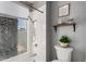 Bathroom featuring a shower with a window, with a toilet and small plants at 5302 W Poinsettia Dr, Glendale, AZ 85304