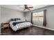Bedroom with a ceiling fan, neutral walls, dark floors, and a comfortable bed with stylish bedding at 5302 W Poinsettia Dr, Glendale, AZ 85304