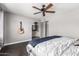 Spacious bedroom with hardwood floors, ceiling fan, guitar, and an ensuite bathroom at 5302 W Poinsettia Dr, Glendale, AZ 85304