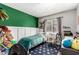Charming bedroom features a green accent wall, wainscoting, and a comfortable single bed at 5302 W Poinsettia Dr, Glendale, AZ 85304