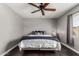 Bedroom with ceiling fan, neutral walls, dark floors, a comfortable bed, and side tables at 5302 W Poinsettia Dr, Glendale, AZ 85304