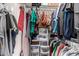 A packed walk-in closet with hanging clothes, boxes, and bins for ample storage at 5302 W Poinsettia Dr, Glendale, AZ 85304