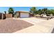 Home's driveway and two-car garage, complimented by a gravel front yard at 5302 W Poinsettia Dr, Glendale, AZ 85304