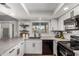 A well-lit kitchen boasts white cabinets, subway tile backsplash, black appliances, and a view from the window at 5302 W Poinsettia Dr, Glendale, AZ 85304
