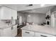 Open concept kitchen featuring white cabinets, countertops, and seamlessly connected to a dining and living area at 5302 W Poinsettia Dr, Glendale, AZ 85304