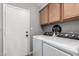 Functional laundry room with washer, dryer, and overhead cabinets for storage at 5302 W Poinsettia Dr, Glendale, AZ 85304