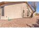 The back exterior of the home features low maintenance rock landscaping and an off-white stucco wall at 5372 S Cat Claw Dr, Gold Canyon, AZ 85118