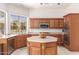 This kitchen is equipped with stainless steel appliances, natural wood cabinets, and a center island with a white countertop at 5372 S Cat Claw Dr, Gold Canyon, AZ 85118