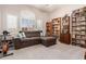 Comfortable living room featuring a sectional sofa, built-in bookshelves, and shuttered windows at 5372 S Cat Claw Dr, Gold Canyon, AZ 85118
