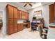 Functional office with built-in wooden cabinets, work surfaces, neutral tile floors, and ceiling fan at 5372 S Cat Claw Dr, Gold Canyon, AZ 85118