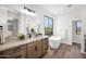 Bathroom featuring double vanities, soaking tub, and view window to capture the natural landscape at 553 W Cavalry Rd, New River, AZ 85087