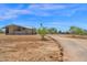 Wide view of a modern home featuring desert landscaping and a long gravel driveway with decorative rock border at 553 W Cavalry Rd, New River, AZ 85087