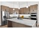 Modern kitchen features stainless steel appliances, granite countertops, and a stylish island with pendant lighting at 553 W Cavalry Rd, New River, AZ 85087