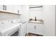 Well-equipped laundry room with modern appliances, utility sink, and ample storage cabinets at 553 W Cavalry Rd, New River, AZ 85087