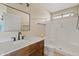 Bathroom featuring a white-tiled shower, black framed mirror, and elegant wood vanity at 5734 W Commonwealth Pl, Chandler, AZ 85226