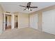Bedroom with neutral carpet, ceiling fan, closet, and doorway to bathroom with brown vanity at 5734 W Commonwealth Pl, Chandler, AZ 85226