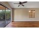 Bright living room featuring hardwood floors, modern ceiling fan, and sliding glass doors to a brick patio at 5734 W Commonwealth Pl, Chandler, AZ 85226