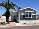 Charming home with gray and blue siding and a well-manicured yard featuring a beautiful palm tree at 625 W Mckellips Rd # 325, Mesa, AZ 85201