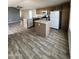 Open kitchen with wood-look tile floors, an island, and modern appliances for easy meal preparation at 625 W Mckellips Rd # 325, Mesa, AZ 85201