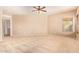 Open bedroom design features plush carpeting, a fan, and natural light at 664 W Silver Reef Ct, Casa Grande, AZ 85122