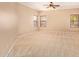 Spacious, carpeted bedroom with multiple windows and fan fixture at 664 W Silver Reef Ct, Casa Grande, AZ 85122