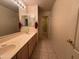 Bathroom featuring dual sinks, a walk-in shower, and neutral tile flooring at 6904 E Trailridge Cir, Mesa, AZ 85207