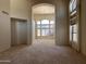 Light-filled living room with tall ceilings, arched entranceway and neutral carpet at 6904 E Trailridge Cir, Mesa, AZ 85207
