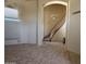 Open-concept living room with staircase and views through arched entryway to dining room beyond at 6904 E Trailridge Cir, Mesa, AZ 85207