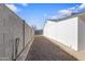 Gravel backyard features a concrete block wall and a white building under a bright blue sky at 7008 W Sierra St, Peoria, AZ 85345