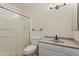 Bathroom featuring a glass door shower, toilet, vanity, and modern lighting fixture at 7008 W Sierra St, Peoria, AZ 85345