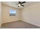 Bright bedroom featuring neutral carpet, a ceiling fan, and a clear window at 7008 W Sierra St, Peoria, AZ 85345
