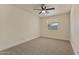 Clean, well-lit bedroom with neutral carpet, ceiling fan and window at 7008 W Sierra St, Peoria, AZ 85345