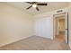 Inviting bedroom featuring a closet with mirrored doors, a ceiling fan, and soft carpet at 7008 W Sierra St, Peoria, AZ 85345