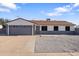 Charming single-story home featuring a gray garage door and a low-maintenance front yard at 7008 W Sierra St, Peoria, AZ 85345