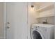 Functional laundry area with washer, dryer, built-in shelving, and convenient access door at 7008 W Sierra St, Peoria, AZ 85345