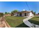 Lush backyard featuring a covered patio, well-maintained lawn, and mature landscaping at 8501 E Malcomb Dr, Scottsdale, AZ 85250