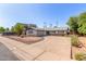 Well-maintained home featuring desert landscaping, mature trees, and a circular driveway at 8501 E Malcomb Dr, Scottsdale, AZ 85250