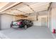 Spacious garage featuring an overhead storage rack, painted walls, a parked car, and a fire extinguisher at 8501 E Malcomb Dr, Scottsdale, AZ 85250