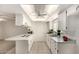 Bright kitchen showcasing white cabinets, tile flooring, and modern appliances under a skylight at 8501 E Malcomb Dr, Scottsdale, AZ 85250