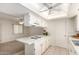 The bright kitchen has a skylight, tile flooring and white cabinets with an eating bar at 8501 E Malcomb Dr, Scottsdale, AZ 85250