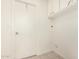 Simple laundry room with overhead cabinets, tile floors, and a door at 8501 E Malcomb Dr, Scottsdale, AZ 85250