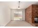 Light-filled living area with a brick fireplace, sliding doors, and neutral carpet at 8501 E Malcomb Dr, Scottsdale, AZ 85250