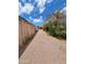 A gravel path leads to a gated backyard, under a sunny, partly cloudy blue sky at 901 S Esperanza Ave, Mesa, AZ 85208
