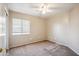 Bedroom features neutral colored walls, carpet, ceiling fan and large window at 9422 W Monroe St, Peoria, AZ 85345