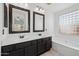 Bright bathroom with dual vanities, framed mirrors, and a soaking tub at 1156 N San Benito Dr, Gilbert, AZ 85234